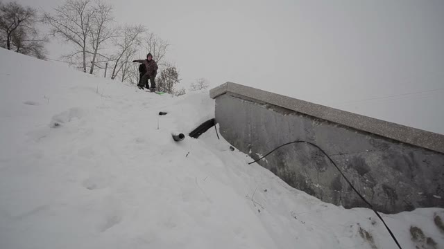 Snowboarder Doing A Slide Trick In The Street