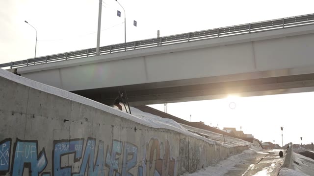 Snowboarder Jumping Over The Road On The Background Of The Sun