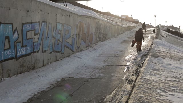 Snowboarders Are Going Up On The Road Under The Bridge