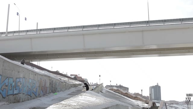 Skier Jumping Over The Street Gap On The Bridge And Sun Background