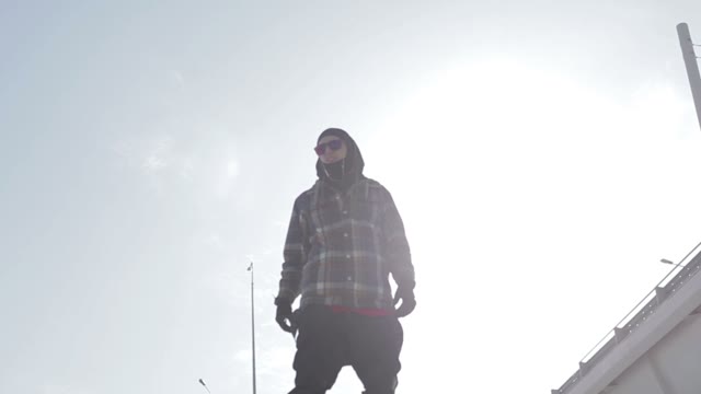 Snowboarder Standing In The Sun Near The Bridge