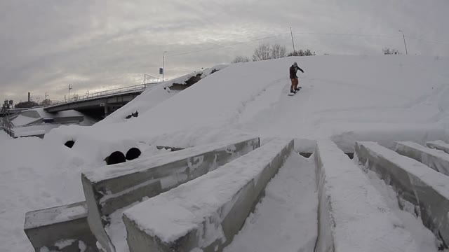 Snowboarder Doing Boardslide On Concrete Blocks In The Street