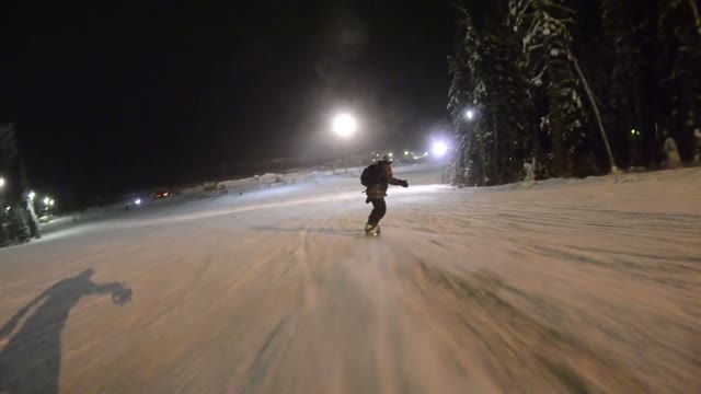 Snowboarder Coming Down The Hill At Night