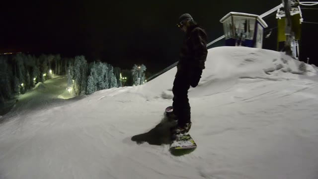 Snowboarder Starts To Move Down The Mountain At Night