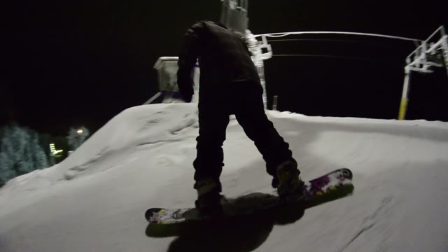 Snowboarder Starts To Move Down The Mountain And Doing Tricks At Night
