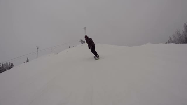 Snowboarder Riding Down And Jumping From Kicker