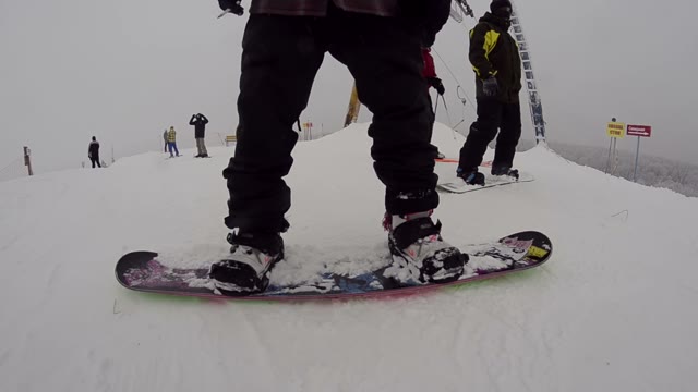 Snowboarder Standing On A Mountain Top In The Snowpark