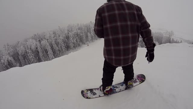 Snowboarder Begins To Move Down From The Mountains And Jumping
