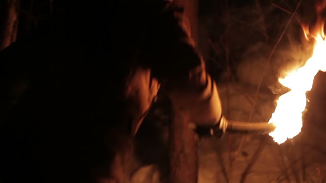 The Young Man Going With The Torch At Night In The Winter Forest