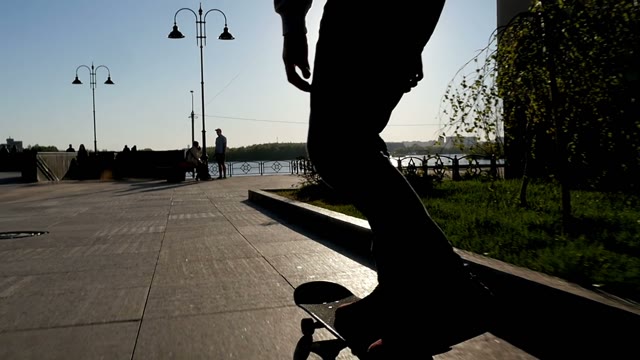 Man Doing A Trick On A Skateboard. Silhouette On A Background Of The Sun