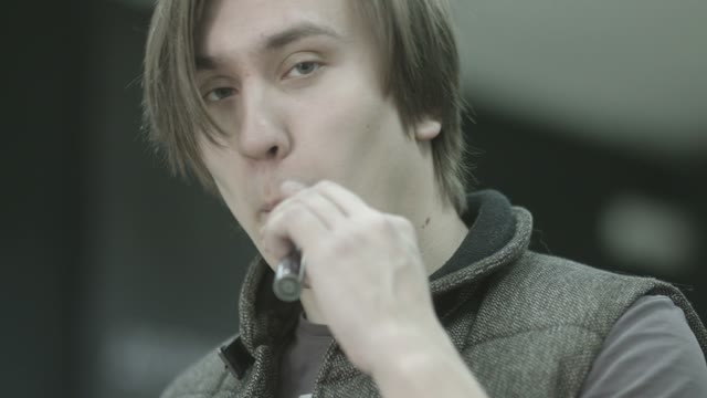 Young Man Smoking Electronic Cigarette