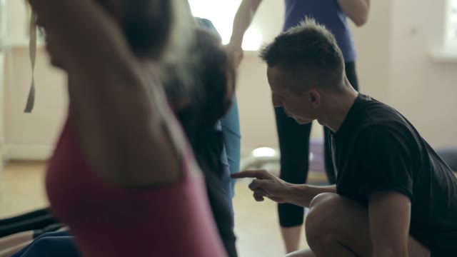 The Trainer Of Yoga Helps Students