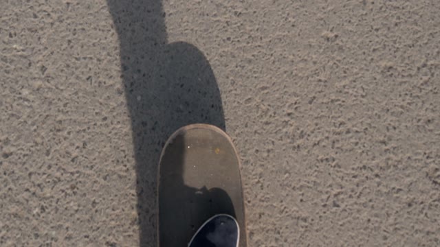Guy Rides A Skateboard On The Asphalt. First-person View