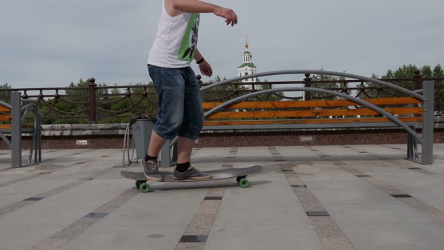 Man Riding His Longboard On The Embankment Of The River