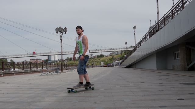 Man Riding His Longboard On The Embankment