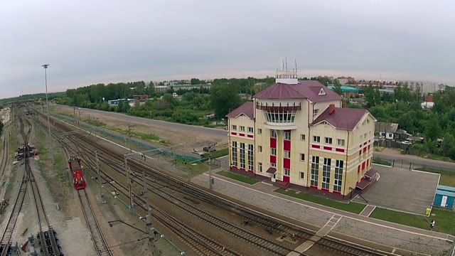 The Locomotive Travels Over Paths On The Background Of The Station Building