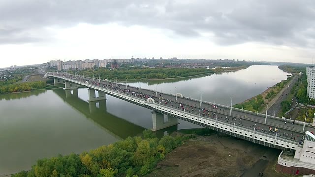 People Running A Marathon Across The River