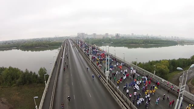 Young People Run A Marathon On The Bridge Over The River