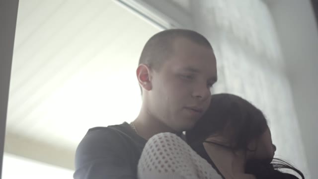 A Young Couple. Young Man Hugs A Girl From Behind