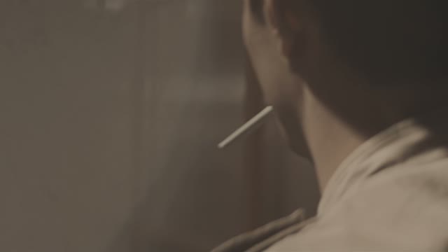 A Young Man Lights A Cigarette