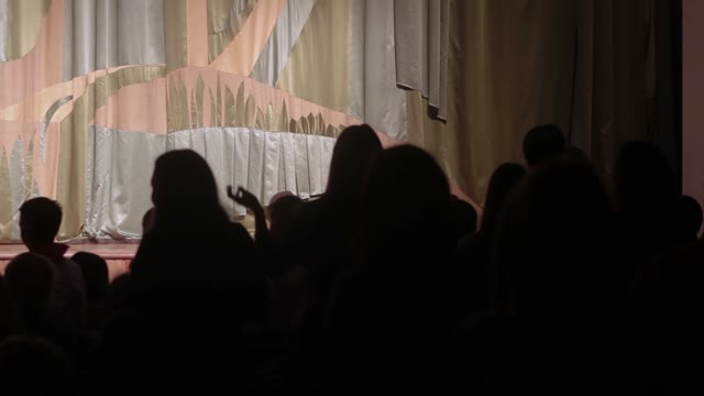 Man Dancing On Stage. Silhouettes Of Spectators