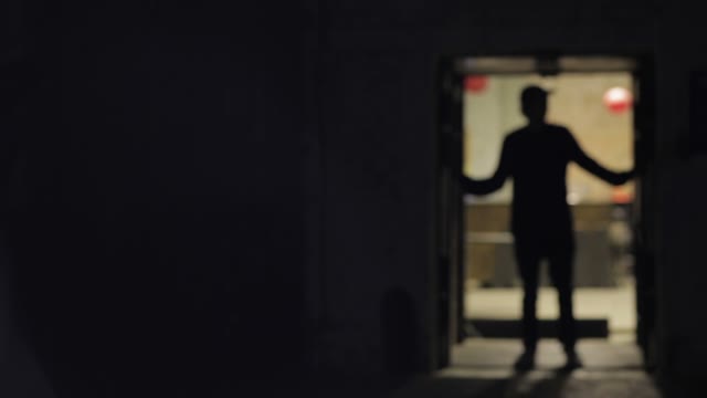 Silhouette Of A Man Closes The Sliding Door