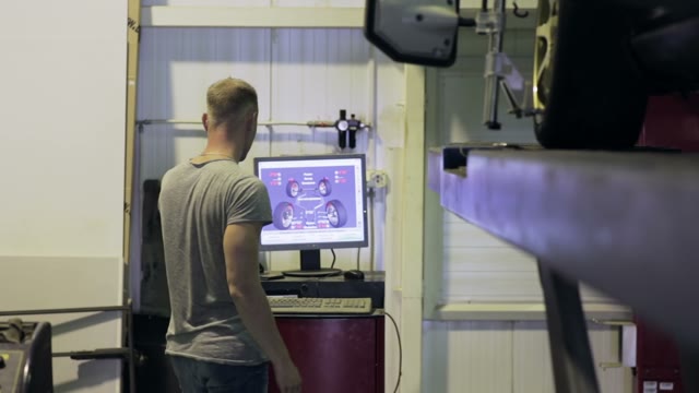 Young Man Looking At The Computer Reading Condition His Car