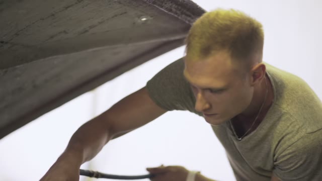 Young Worker Dries Engine