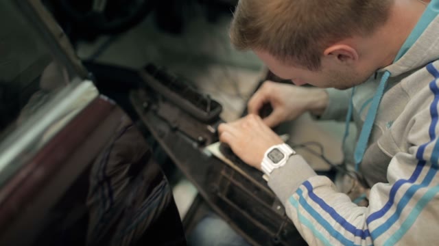 A Mechanic Checks The Wiring In The Dashboard
