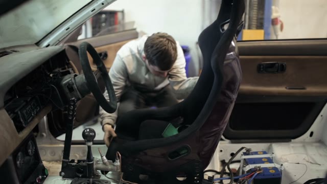 Mechanic Installs A Sports Seat In The Car