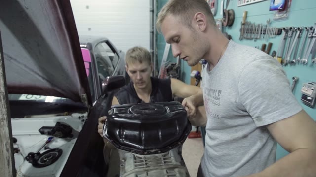 Two Mechanics Try On The Size Of The Items To Be Installed