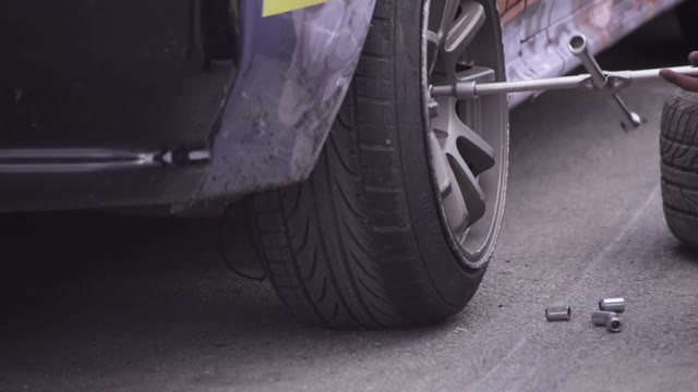 Mechanic Changing Tires On A Race Car