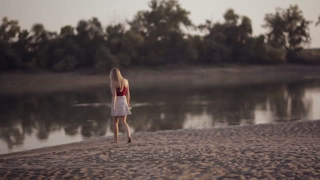 Young Beautiful Blonde Walks By The River