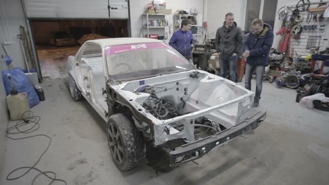 Young Workers Prepare The Car For Painting
