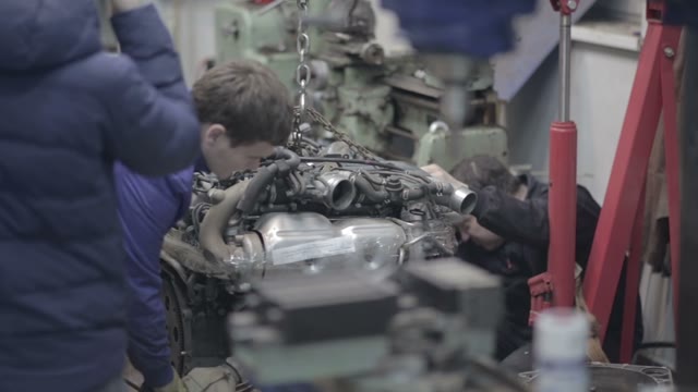 Workers Inspect The Car Engine