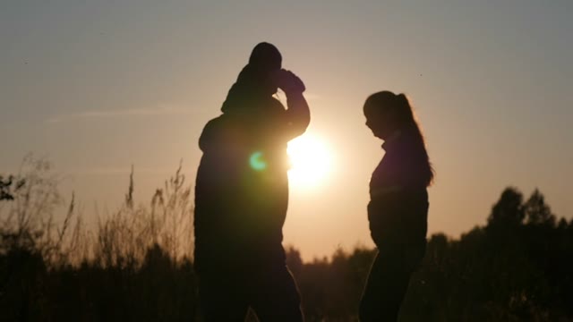 Young Couple Playing With Baby On Sunset