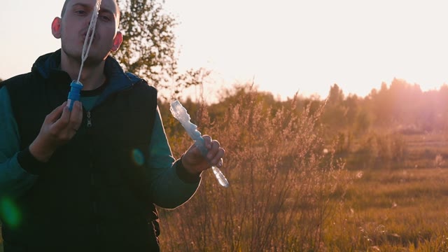 Man Starts Up Soap Bubbles On A Sunset