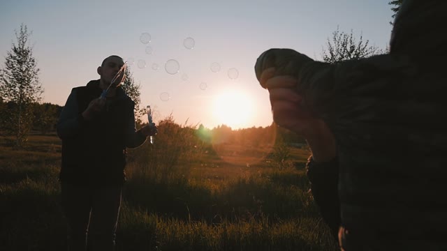 Young Couple Playing With Soap Bubbles