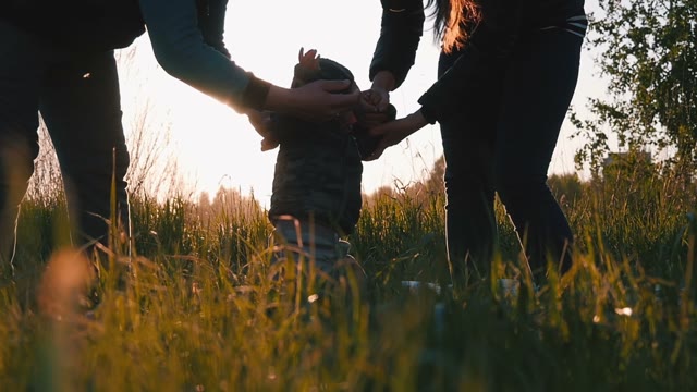 Couple Playing With A Small Child At Sunset