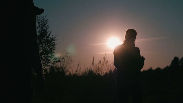 Young Couple Walking With A Child In The Sunset