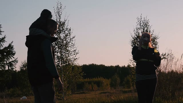 Young Couple Playing With Soap Bubbles On Nature