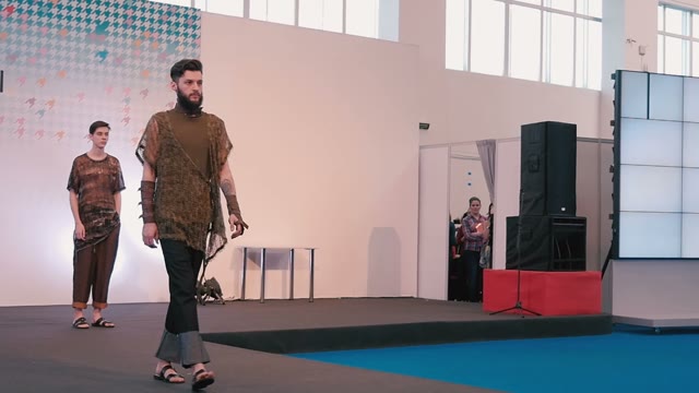 Fashion Show. Male Model In The Dresses Go On The Catwalk
