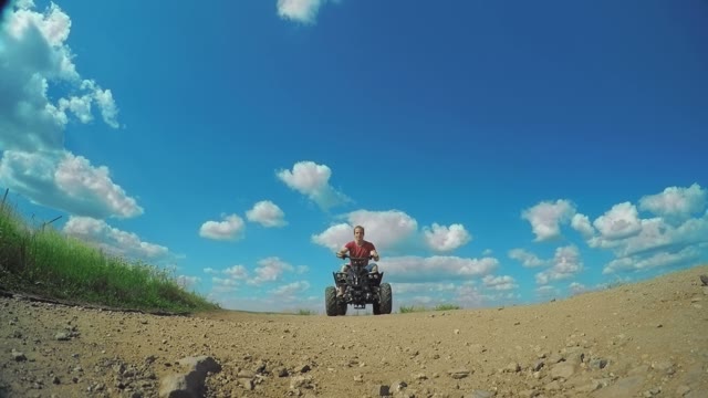 A Young Man On The Quad Bike Rides Over The Camera