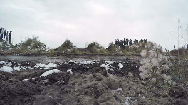Off-road Car Driving On A Dirt Road And Passes Through A Puddle