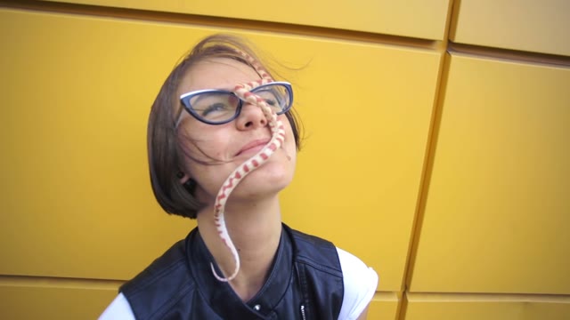 Pretty Young Woman Posing With A Snake On The Street