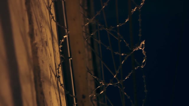 Large Fence With Barbed Wire In The Night
