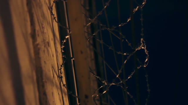 Large Fence With Barbed Wire In The Night