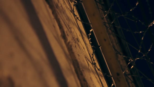 Large Fence With Barbed Wire In The Night