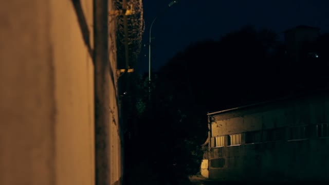 Large Fence With Barbed Wire In The Night