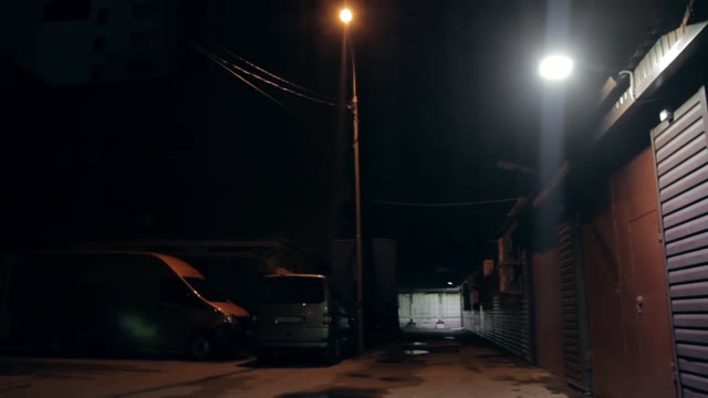 Garages And Parked Next Car. Night Lighting Of The Lamp